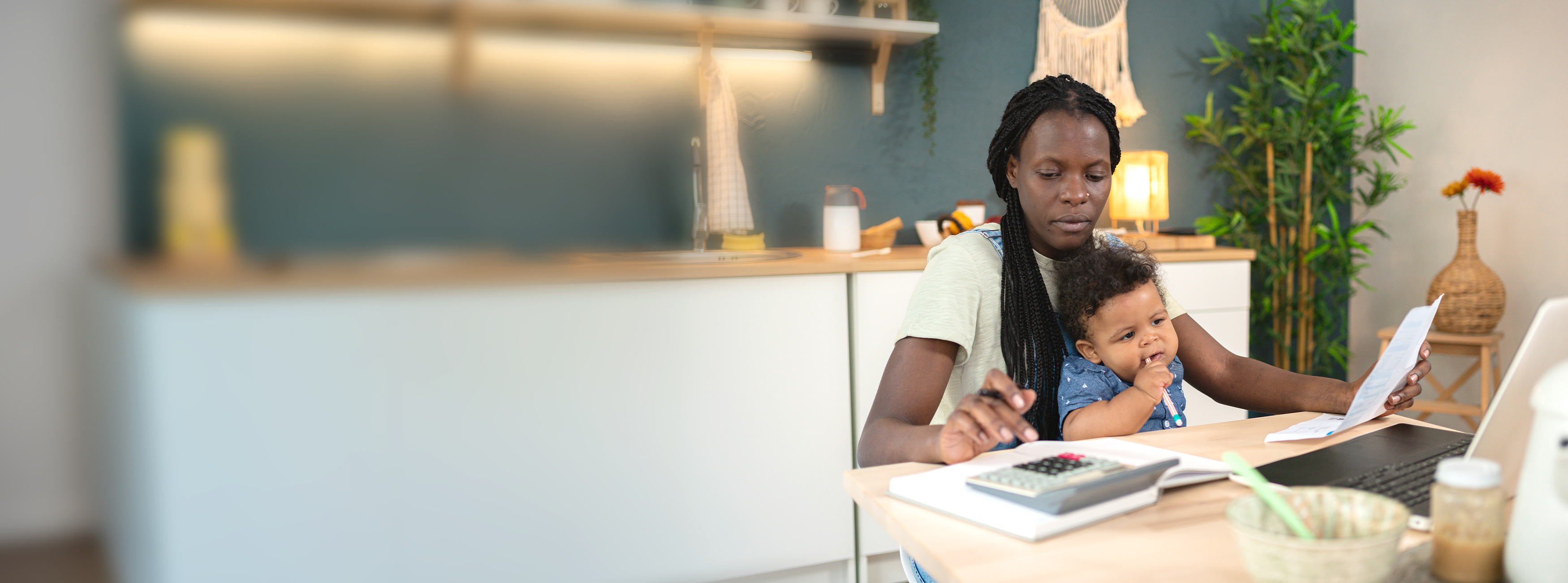 Mother calculating finances with her baby on her lap